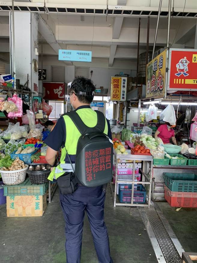 清水警分局员警3日举着宣导标示牌并背着活动led跑马灯，前往辖内各菜市场宣导各项防疫政策。（清水警分局提供／陈淑娥台中传真）