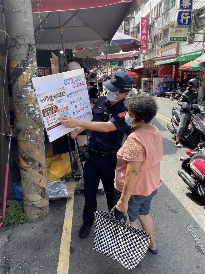 清水警分局员警3日举着宣导标示牌并背着活动led跑马灯，前往辖内各菜市场宣导各项防疫政策。（清水警分局提供／陈淑娥台中传真）