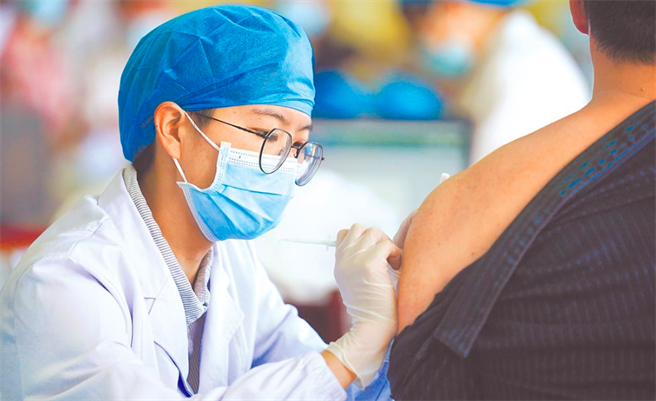 图为大陆医护人员为市民接种疫苗。（中新社）