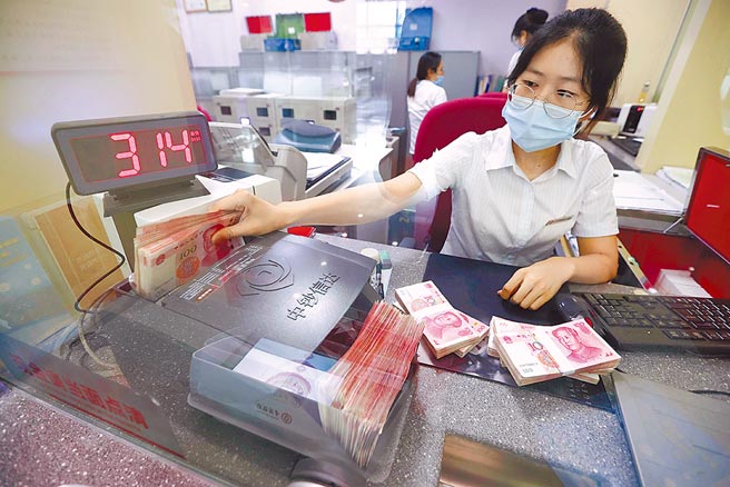 人民币1年来强劲升值12％，引起市场投机者蠢动。图为山西省太原市1行员清点钞票。（中新社）