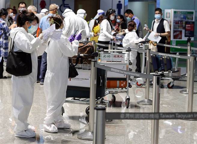 3日傍晚桃園機場出境旅客身穿全副武裝防護衣辦理出境登機手續。（圖／本報系資料照）