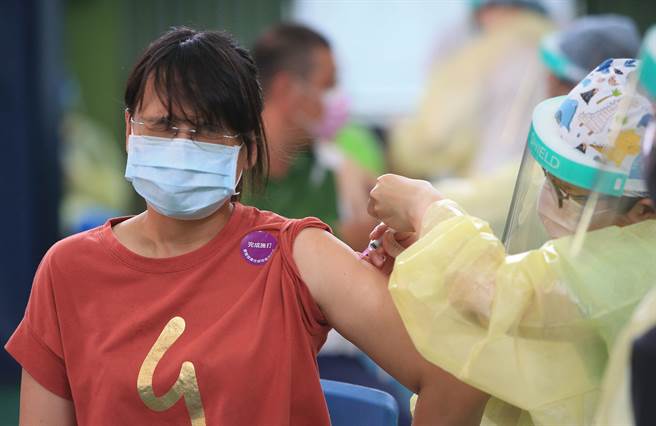 台中市於29區布建66處疫苗快打站，其中5處於4日優先「實兵演練」圖中為位於大里塗城國小的快打站，一位第一類人員，正接受疫苗接種。（黃國峰攝）