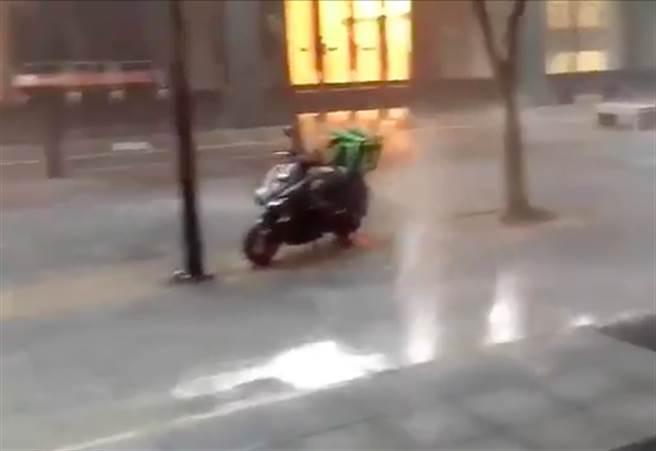 今（4）日信義區午後瞬間暴雨，馬路驚現「水舞秀」，水溝一秒變噴泉蓋過機車。（圖／熱心民眾提供）