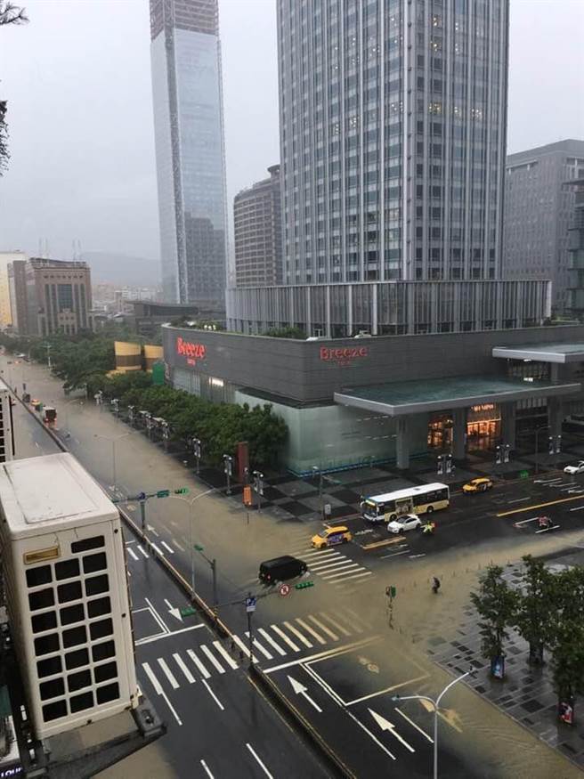 今（4）日信義區午後瞬間暴雨，馬路驚現「水舞秀」，水溝一秒變噴泉蓋過機車。（圖／熱心民眾提供）