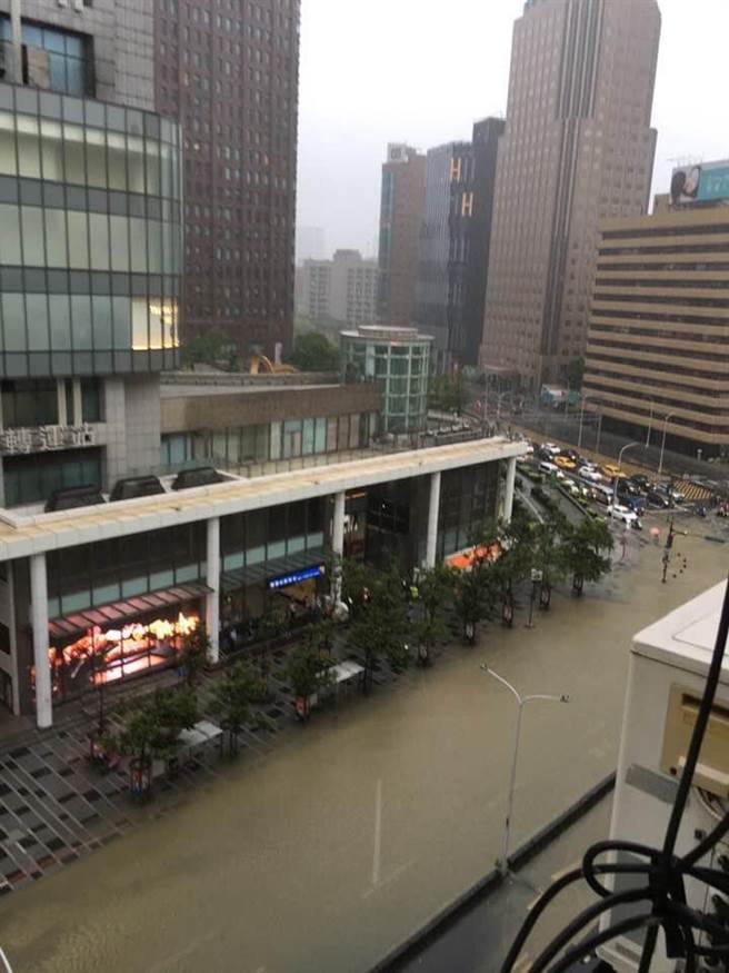 今（4）日信義區午後瞬間暴雨，馬路驚現「水舞秀」，水溝一秒變噴泉蓋過機車。（圖／熱心民眾提供）