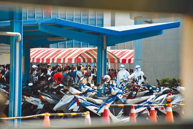 京元電竹南廠驚爆群聚感染，快篩站3日聚集許多員工等候PCR檢測及快篩。（謝明俊攝）