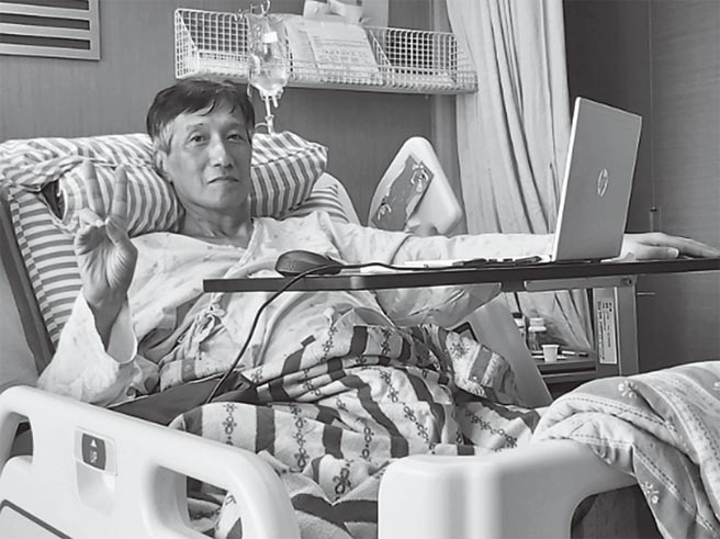 在病床上写书的爸爸，看起来神采飞扬。（时报出版提供）