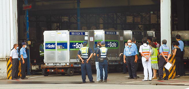 首批日本捐赠的124万剂AZ疫苗4日由日航班机载运来台，班机抵达桃园机场后，装载疫苗的冷冻货柜在重重戒护下准备通关。（范扬光摄）