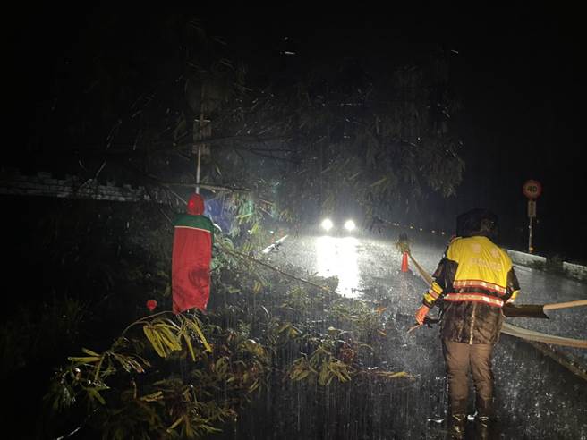 员警持简易工具，在大雨中徒手清理倾倒路树障碍，费了近2小时终完成清理，恢復双向通行。（竹山分局提供／卢金足南投报导）