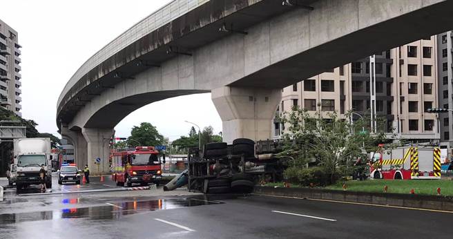 高雄市楠梓区南阳路和加昌路交叉路口7日上午10时发生一起车祸，一辆水泥预拌车自撞安全岛翻覆，驾驶受困车中，消防局人员到场抢救。（摘自我是楠梓人脸书／林瑞益高雄传真）