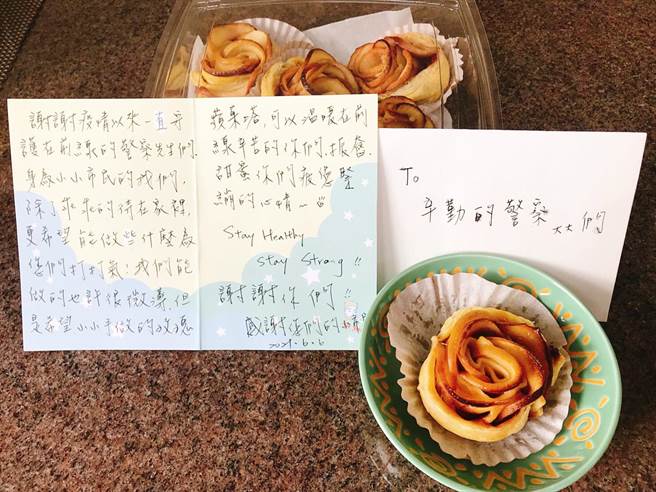 陳姓女子6日晚間8時許，當時正下著大雨還是撐著傘帶著手寫卡片及自製的玫瑰蘋果塔，送至板橋警分局盼可以分享溫暖前線辛苦的警察們。（板橋警分局提供）