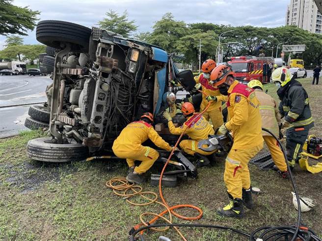 一辆水泥车7日上午行经楠梓区高楠公路和加昌路的交叉路口，因不明原因翻车，消防局人员到场抢救。（翻摄照片／林瑞益高雄传真）
