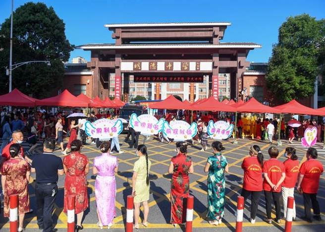 湖南长沙一群考生家长穿旗袍，寓意「旗开得胜」。（中新社）