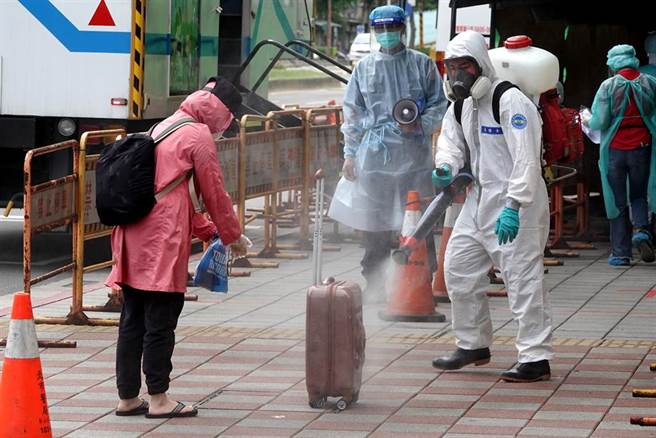 若快筛结果为阳性，将马上被防疫专车载往集中检疫所，等待PCR结果。有民眾预防万一，拖着行李箱前来快筛，所幸结果是阴性，离去时特别请国军化学兵替她全身消毒后再回家。（黄世麒摄）