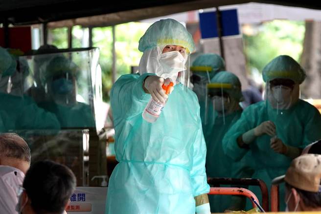 筛检站工作人员全副武装，手持酒精喷灌随时替民眾消毒。（黄世麒摄）
