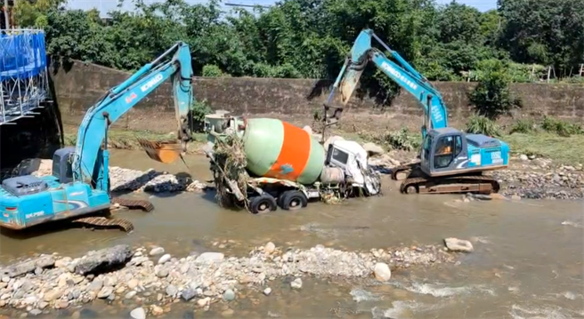 桃园市中坜区一处河床进行拓宽作业时，因溪水暴涨，水泥车与怪手均被冲走。（民眾提供）