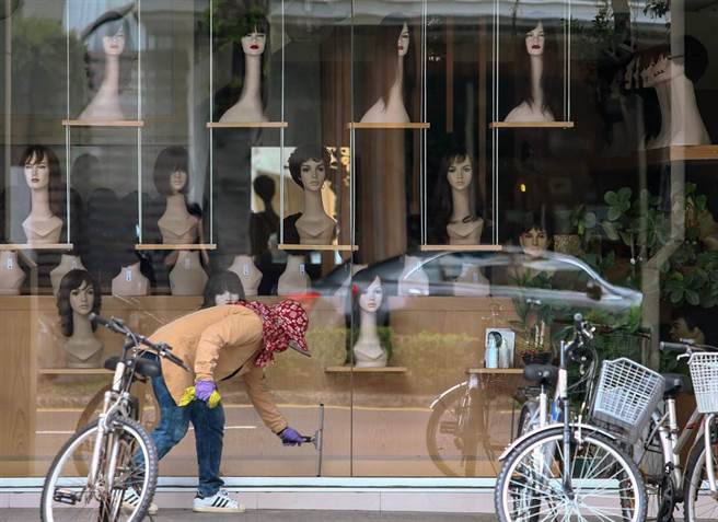 因疫情关系，天母一家美髮店虽暂时停止营业，但清洁工仍努力的清洁橱窗，让客人可以看见乾净的门面，橱窗上的假人也似乎看着橱窗外，盼望客人哪时候可以再度光临。全国商总理事长许舒博8日表示，台湾疫情来的又急又猛，部分产业陷入即刻停工、业绩归零、员工生计难以为继的生死关头，（邓博仁摄）
