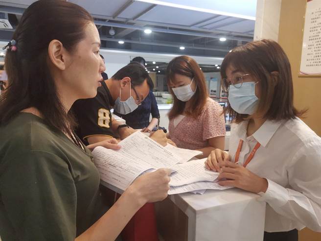 台胞胡文麗（圖左一）在儀式啟動現場諮詢工作人員有關分娩的健保核銷事宜（大公文匯全媒體）