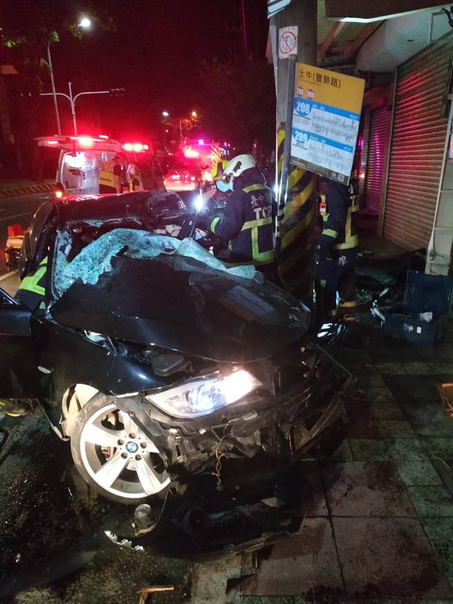 黑色BMW撞上電線桿及公車站牌，擋風玻璃全碎，駕駛受困變形車內長達2多小時。（台中市消防局提供／王文吉台中傳真）