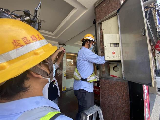 高雄市新興區1家養生館關門違規從事性交易，市府稽查小組今執行斷水斷電措施，圖為台電人員進行拔除電錶作業。（石秀華攝）