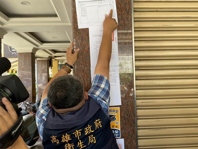市府衛生局人員對高市違規營業的養生館張貼衛福部處分公告。（石秀華攝）