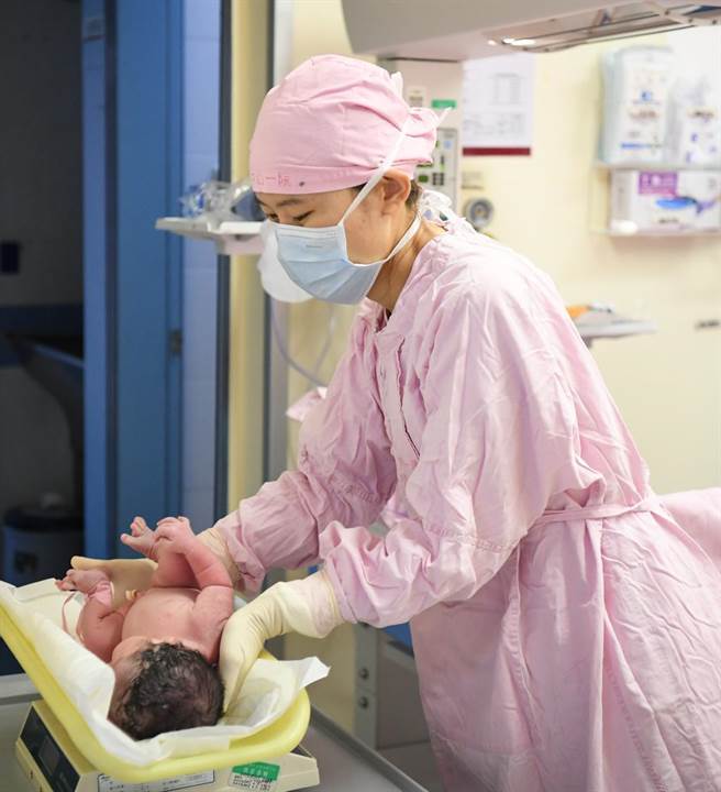 大疫當前傳好消息，廣州52位孕婦順利生產。圖為去年中山大學附屬第一醫院婦產科給剛出生的嬰兒稱重。（摘自新華社）