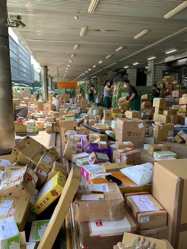 交通部長王國材PO出一張照片，顯示郵局員工在炎熱中處理滿地包裹。（摘自王國材臉書／陳祐誠傳真）