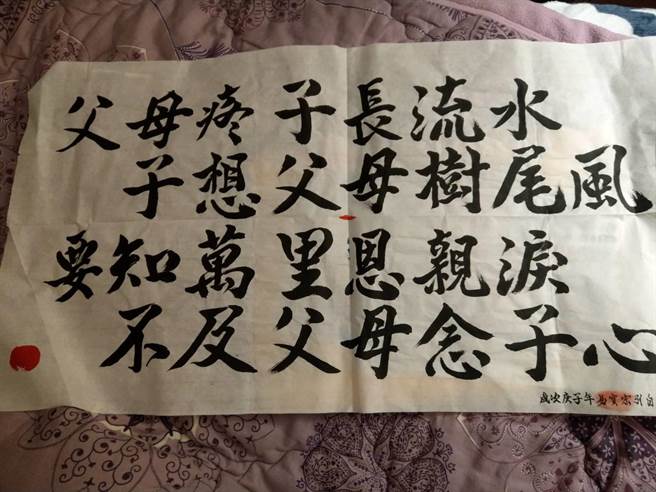 易淑宽秀出儿子的墨宝。（万鸿提供）