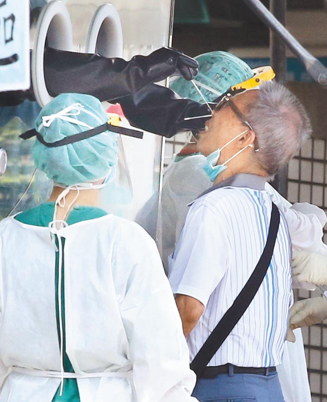 新冠肺炎本土疫情持续延烧，新北市每日确诊人数仍居高不下，在新北市立联合医院三重院区的快筛站内，许多民眾9日前往排队採检。（范扬光摄）