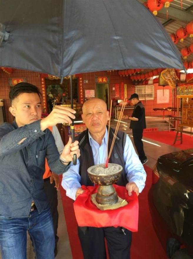 作者替作为值年炉主的大伯搭伞，迎着传承数百年的妈祖香炉前往家中。（作者提供）