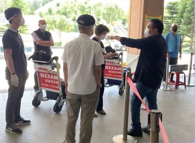 金门县府在机场设置快筛站，2名旅客（中）一度拒绝採检。县府工作人员在旁不断说明和劝导。（民眾提供）