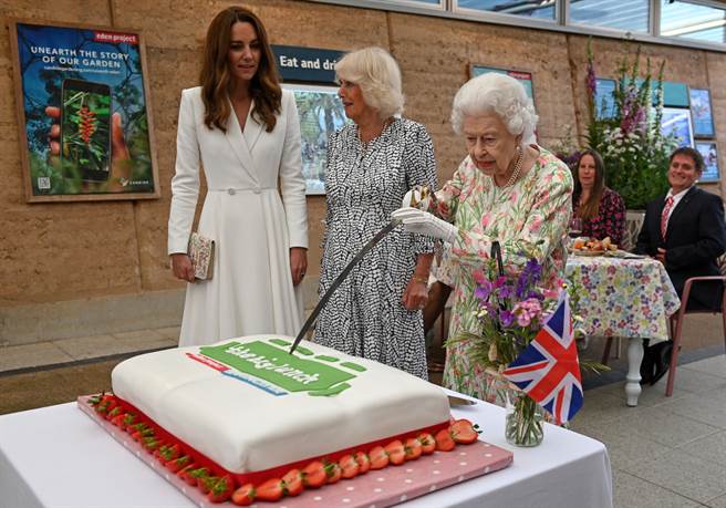 英国女王6月11日在康瓦尔出席午餐飨宴（The Big Lunch）活动时，拿起长剑，认真切着蛋糕，而一同出席的凯特和卡蜜拉则在一旁观看。（路透）