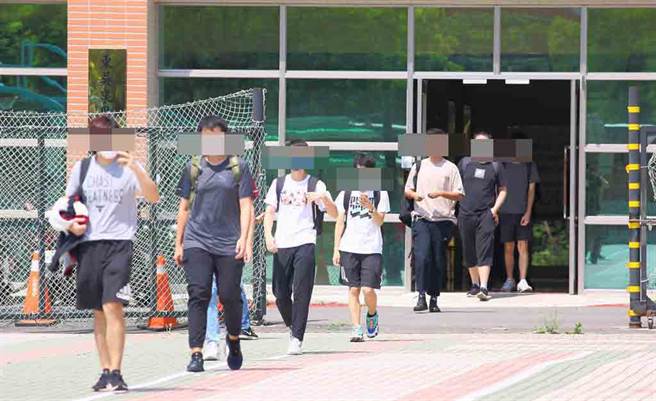 东吴大学11日晚间在官网宣布有一名学生确诊，其位于北投泉思学舍的宿舍紧急清消，12日校方与台北市府讨论后，安排男生宿舍内的60名学生与12名教职员到万华剥皮寮筛检站进行快筛，有学生并配戴全罩式面罩，如临大敌。（张铠乙摄）
