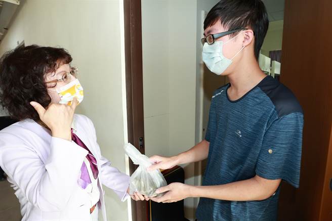 高雄大學校長陳月端（左）送粽子給學生，感謝學生配合防疫政策。（高雄大學提供／林瑞益高雄傳真）