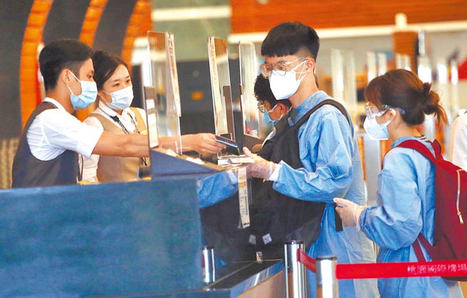 陳時中表示，疫苗護照只是文件、不是證件，施打國產疫苗一樣可以出國，「差別只在於檢疫過程」。圖為桃園機場第一航廈出境大廳內，身穿防護衣的旅客正在辦理報到手續。（范揚光攝）