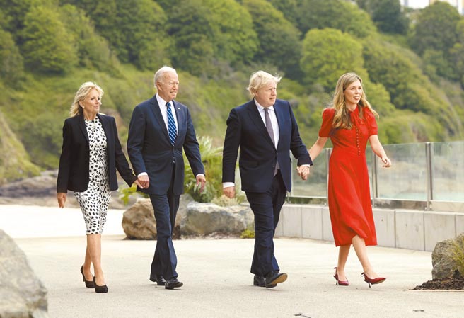 美國總統拜登（左二）10日在英國康瓦爾郡度假勝地卡比斯，與英國首相強森（右二）首度面對面會談。雙雙偕妻在風光明媚的海濱散步。（英國首相府提供）
