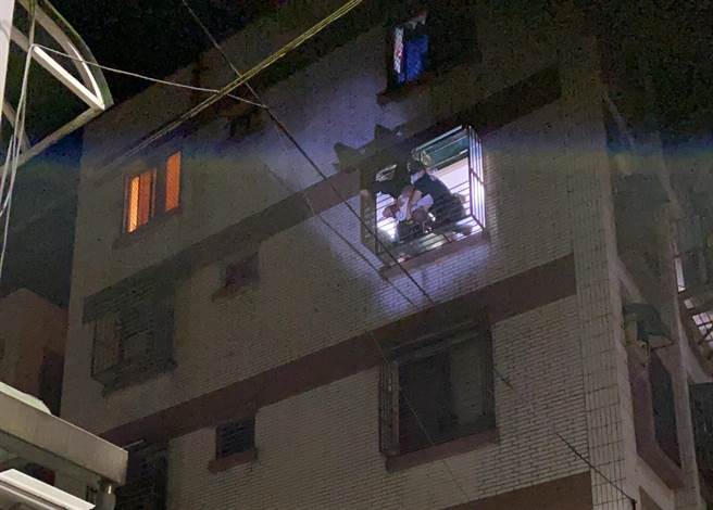 王男因未带钥匙，欲从自家顶楼爬窗返家，不慎失足，右脚卡进4楼住家遮雨棚，倒挂在防盗窗框外围。（基隆市消防局提供／陈彩玲基隆传真）