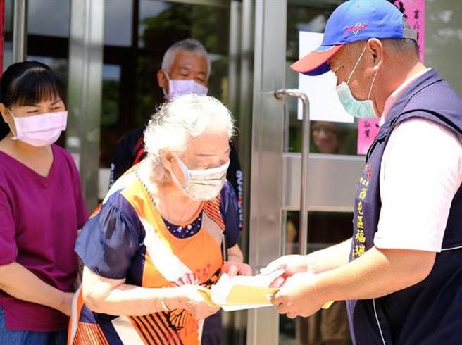 西屯區福瑞里長林添憶，今天至里內住戶投遞「施打疫苗通知單」，提醒住戶要攜帶通知單、身分證及健保卡雙證件、疫苗接種評估及意願書到永安國小注射。（台中市政府提供）