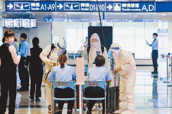 指挥中心13日宣布，7月起，长程航班机组员未接种疫苗返台检疫天数为7+7，接种1剂者维持3+11。图为桃园机场旅客全副武装入境。（陈麒全摄）