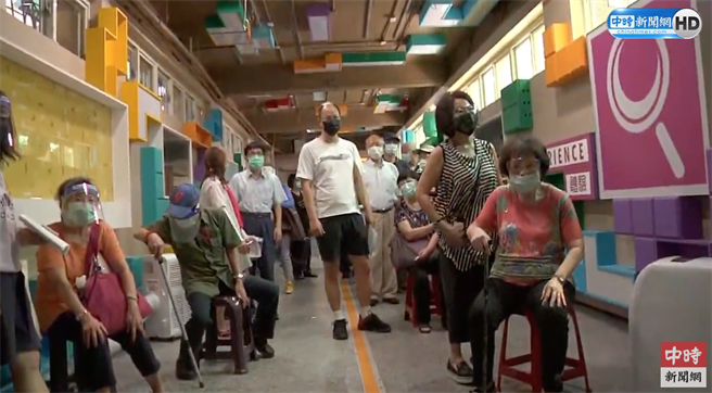 圖為老人家等著打疫苗，有人站累了找椅子坐，沒椅子的人只能站著。（中時新聞網youtube)