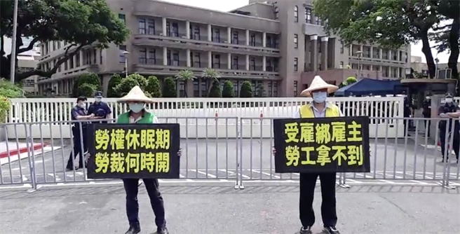 工会成员今日于行政院前举牌一小时抗议，并喊出「雇绑雇主，劳工拿不到，劳权休眠期，劳裁何时开」的口号。（取自美丽华工会记者会直播）