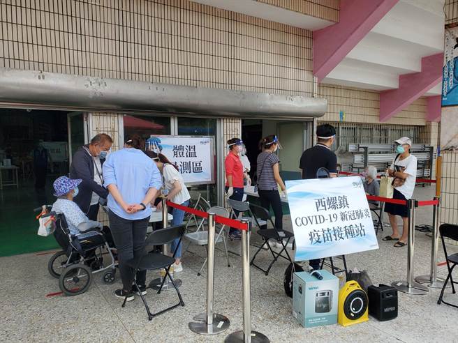 接种的民眾统一在快打站门口量体温。（周丽兰摄）