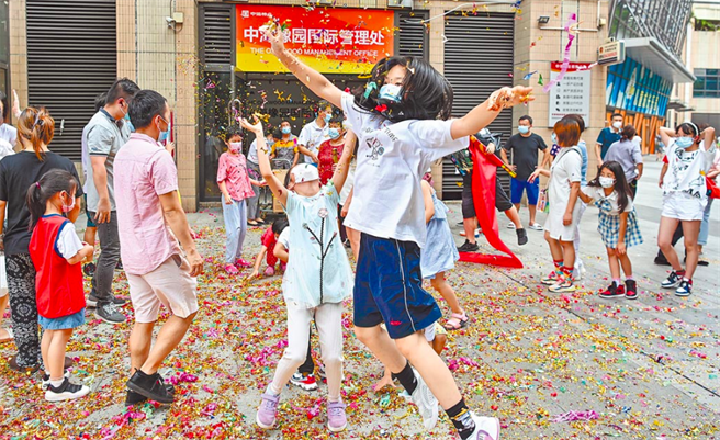 广州市14日解除海珠、天河、白云、黄埔、番禺5个区11个区域的封闭、封控管理措施，沙园街中海橡园小区居民庆祝小区解除封控管理。（中新社）