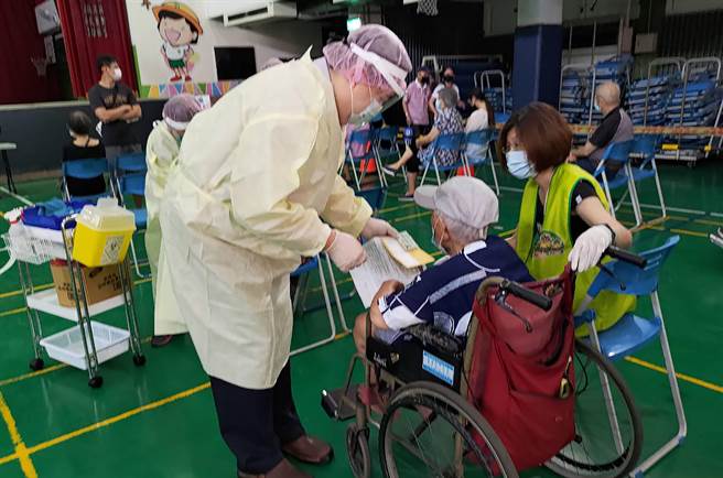 台中市15日起開放85歲以上長輩，施打AZ新冠肺炎疫苗，其中塗城國小快打站，穿著黃背心的老師，協助長者到注射區，幫忙翻譯醫生的專業術語。（塗城國小提供／黃國峰台中傳真）