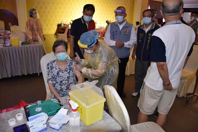 長者害怕打針，在針頭注入剎那，忍不住閉眼鎖眉。（謝明俊攝）