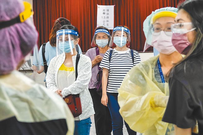 端午连假，仍有许多人到北市疫苗站接种，并担心可能群聚感染，所以穿戴着防护装备到场。（黄子明摄）