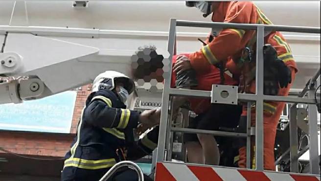 ▲64歲老婦身站5樓公寓鐵窗外動彈不得，直待消防人員以雲梯車營救才平安抵地。（桃園警分局提供／蕭靈璽桃園傳真）