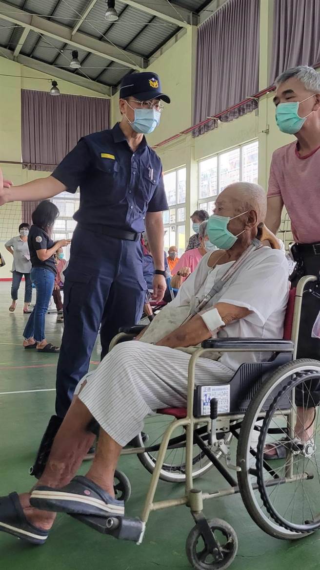 學甲警分局長翁誌宏（左）親自到施打疫苗會場替長者導引服務。（讀者提供／張毓翎台南傳真）