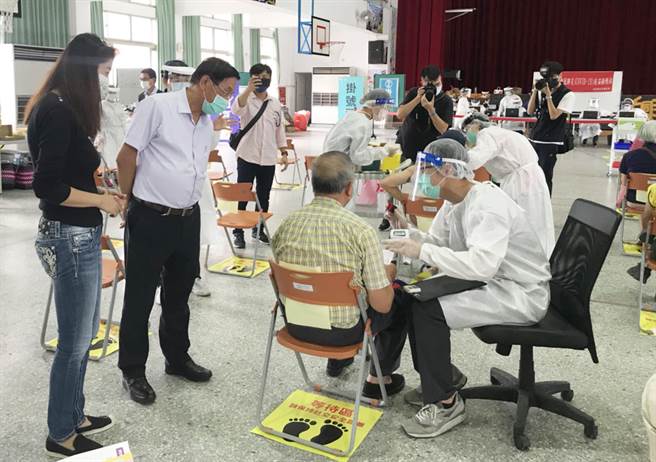 南投县长林明溱（左二）、立委许淑华（左一），昨天到南投市漳兴国小大型接种站，了解老人家接种情形，并向陪同家属致意。（南投县政府提供／陈世宗南投传真）