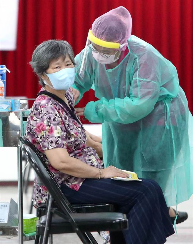 一位長者在護士施打疫苗時，自然的別過頭來不敢看打針的部位。（鄭任南攝）
